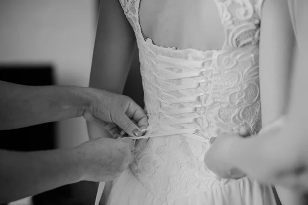 Bridesmaid is helping the bride to dress — Stock Photo, Image