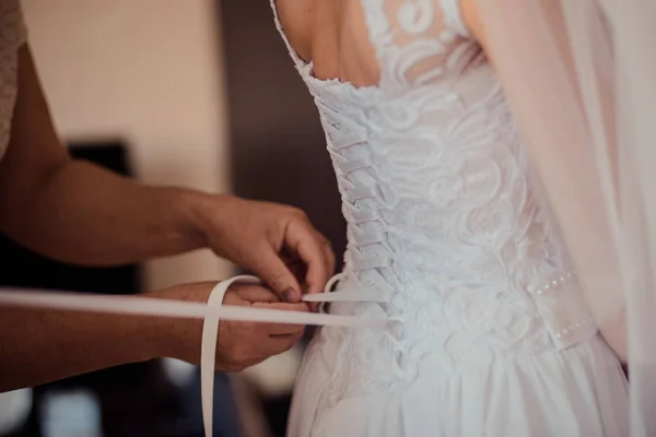 Demoiselle d'honneur aide la mariée à s'habiller — Photo