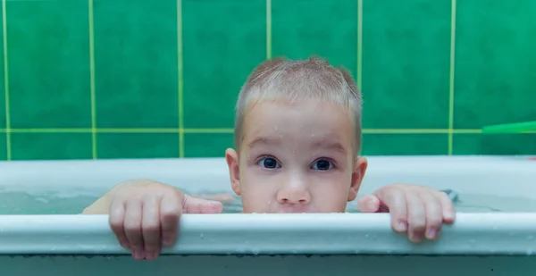 Pojke i vitt badkar på vit bakgrund — Stockfoto