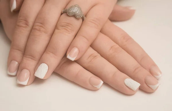 Lichte manicure in licht op een witte achtergrond. — Stockfoto