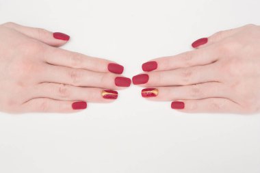 Beyaz arka planda tırnak kırmızısı manikürlü el.