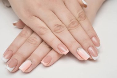 Elleri manikürlü tırnaklar kürk arka plan üzerinde pembe oje ile kaplı