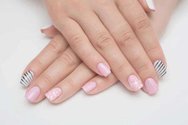 Manicura con pedrería en forma de corazones y bolas de color rosa sobre uñas blancas y rojas Esmalte sobre fondo blanco . —  Fotos de Stock