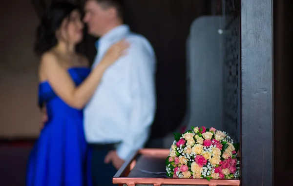 Demoiselle d'honneur avec des fleurs sur le fond du mariage — Photo