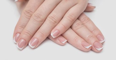 Kalpleri ve beyaz bir arka plan üzerinde beyaz ve kırmızı oje pembe top şeklinde rhinestones ile manikür.