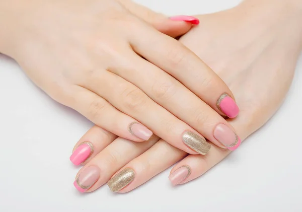Belas mãos femininas com esmalte rosa em um fundo branco, tratamentos de spa — Fotografia de Stock