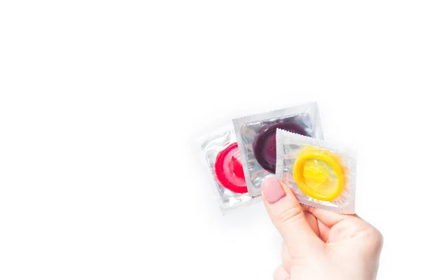 Beyaz arka planda izole edilmiş kadın elinde renk prezervatifi — Stok fotoğraf