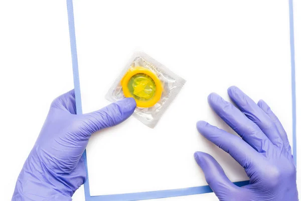 Pembe arka planda izole edilmiş kadın elinde renk prezervatifi — Stok fotoğraf