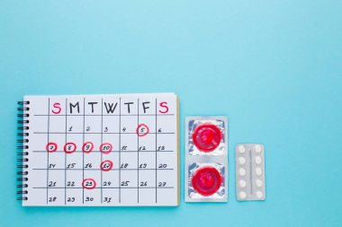 Doğum kontrol hapları ve prezervatifli kadın elleri
