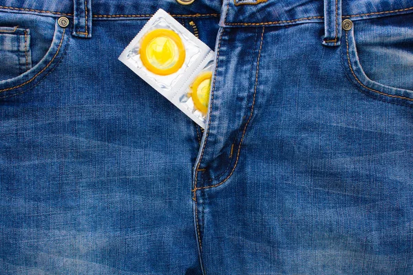 Желтый презерватив в джинсах карманный образ жизни мужчин — стоковое фото