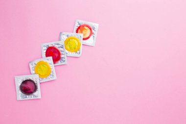 Pembe arka planda izole edilmiş renk prezervatifi