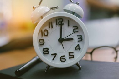 Saat 9 'da tahta masaya defter ya da not defteriyle birlikte retro saat zamanı, günlük yazma anı konsepti klasik ton.