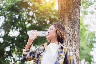 Ormandaki şişeden su içen kız