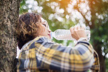 Ormandaki şişeden su içen kız