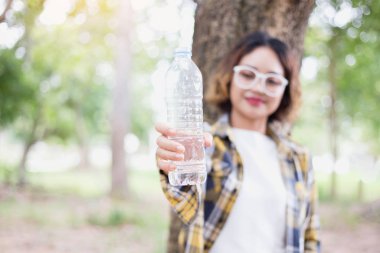 Ormandaki şişeden su içen kız