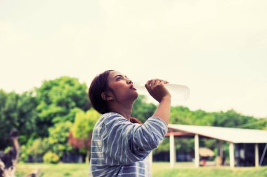 Ormandaki şişeden su içen kız