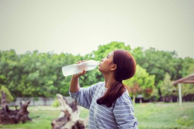 Ormandaki şişeden su içen kız