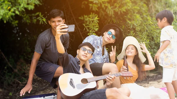 Group of asian teenager have party and drinks beer on the beach