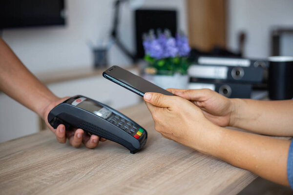Woman paying credit card with payment terminal and cashier man stock photo