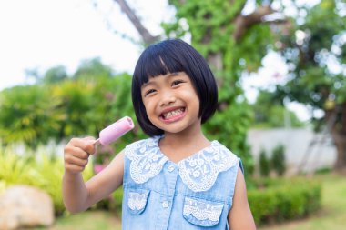 Parkta dondurma yiyen küçük çocuk. 