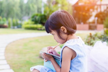 Bulanık yeşil arka planda mutlu tatlı kız çocuğu.