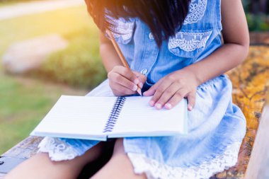 Bulanık yeşil arka planda mutlu tatlı kız çocuğu.