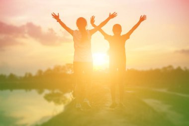 Gün batımında güçlü kendine güvenen kadın kollarını aç.. 