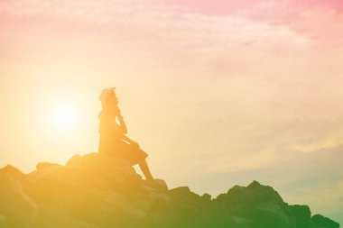 Güzel bir arka plan için dua eden bir kadın silueti.