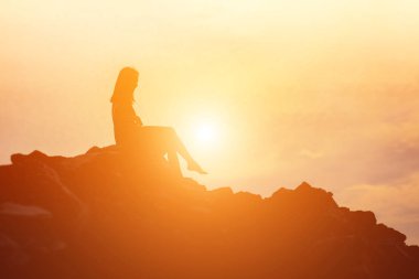 Güzel bir arka plan için dua eden bir kadın silueti.