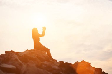 Güzel bir arka plan için dua eden bir kadın silueti.