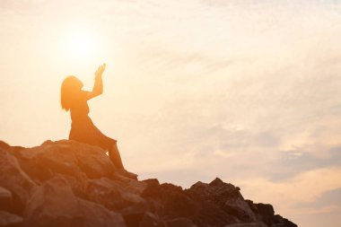 Güzel bir arka plan için dua eden bir kadın silueti.