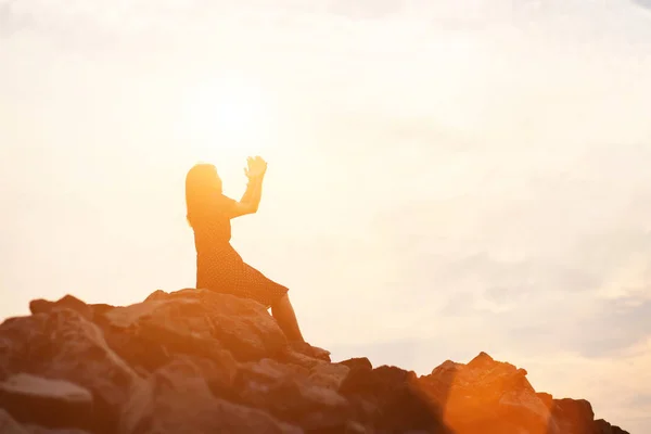 silhouette of woman praying over beautiful sky background