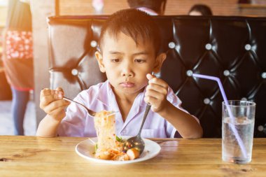 Küçük tatlı çocuk, öğle yemeği için evde spagetti yiyor, lezzetli.