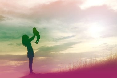 Gün batımında yürüyen Mather ve küçük kızının siluetleri.