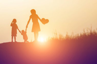 Siluetleri mutlu ebeveynlerin kendi küçük ile iyi vakit geçiriyor 