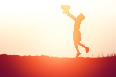 Mutlu bir genç kızın silueti ellerde, kalbini verir.