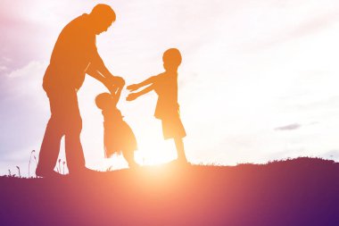 Baba ve küçük kızı günbatımında yürüyüş siluetleri