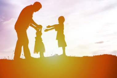 Baba ve küçük kızı günbatımında yürüyüş siluetleri