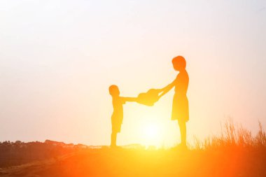 Gün batımının önünde mutlu bir genç kızın silueti.