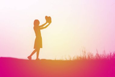 Genç ve mutlu bir kızın silueti. Sevgisinin kolları. 