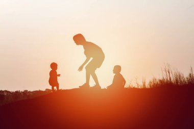 Anne oğlunu açık havada, günbatımı, siluet kavramı teşvik