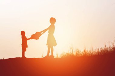 Anne oğlunu açık havada, günbatımı, siluet kavramı teşvik