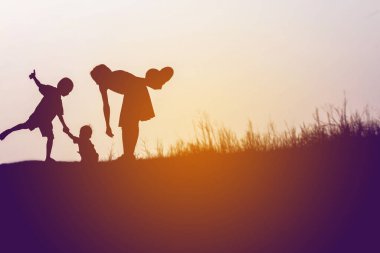 Anne oğlunu açık havada, günbatımı, siluet kavramı teşvik
