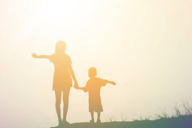 Anne oğlunu gün batımında dışarıda cesaretlendirdi.