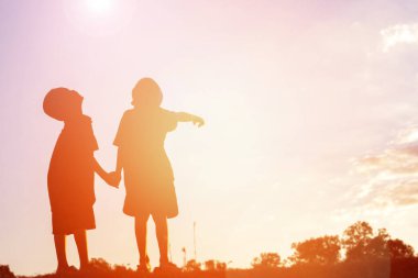 mutlu bir çocuk silüeti ve mutlu zaman günbatımı