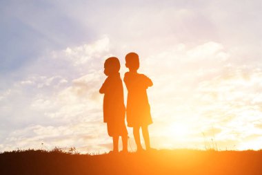 mutlu bir çocuk silüeti ve mutlu zaman günbatımı