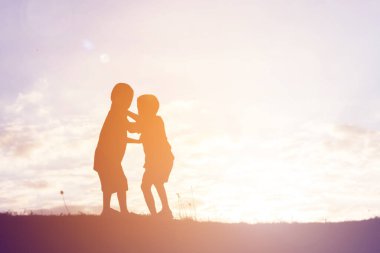 mutlu bir çocuk silüeti ve mutlu zaman günbatımı