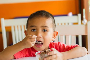 Küçük tatlı çocuk, öğle yemeği için evde spagetti yiyor, lezzetli yemekler yiyor.