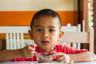 Küçük tatlı çocuk, öğle yemeği için evde spagetti yiyor, lezzetli yemekler yiyor.