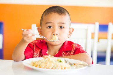 Küçük tatlı çocuk, öğle yemeği için evde spagetti yiyor, lezzetli yemekler yiyor.